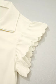Cream cotton blouse with stand-up collar, zip front, and ruffled scalloped cap sleeves.