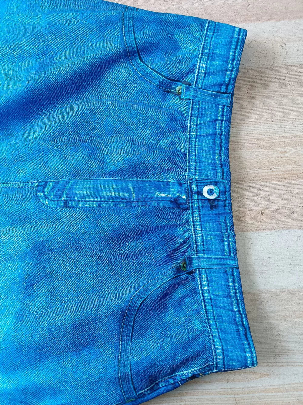 Blue denim asymmetrical top and slit skirt ensemble with pocket details.
