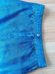 Blue denim asymmetrical top and slit skirt ensemble with pocket details.