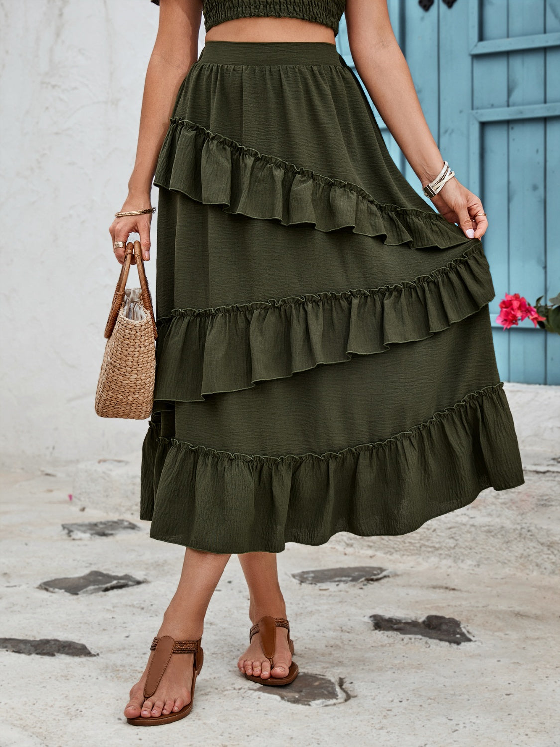Tiered midi skirt in dark green with ruffled tiers and textured fabric.