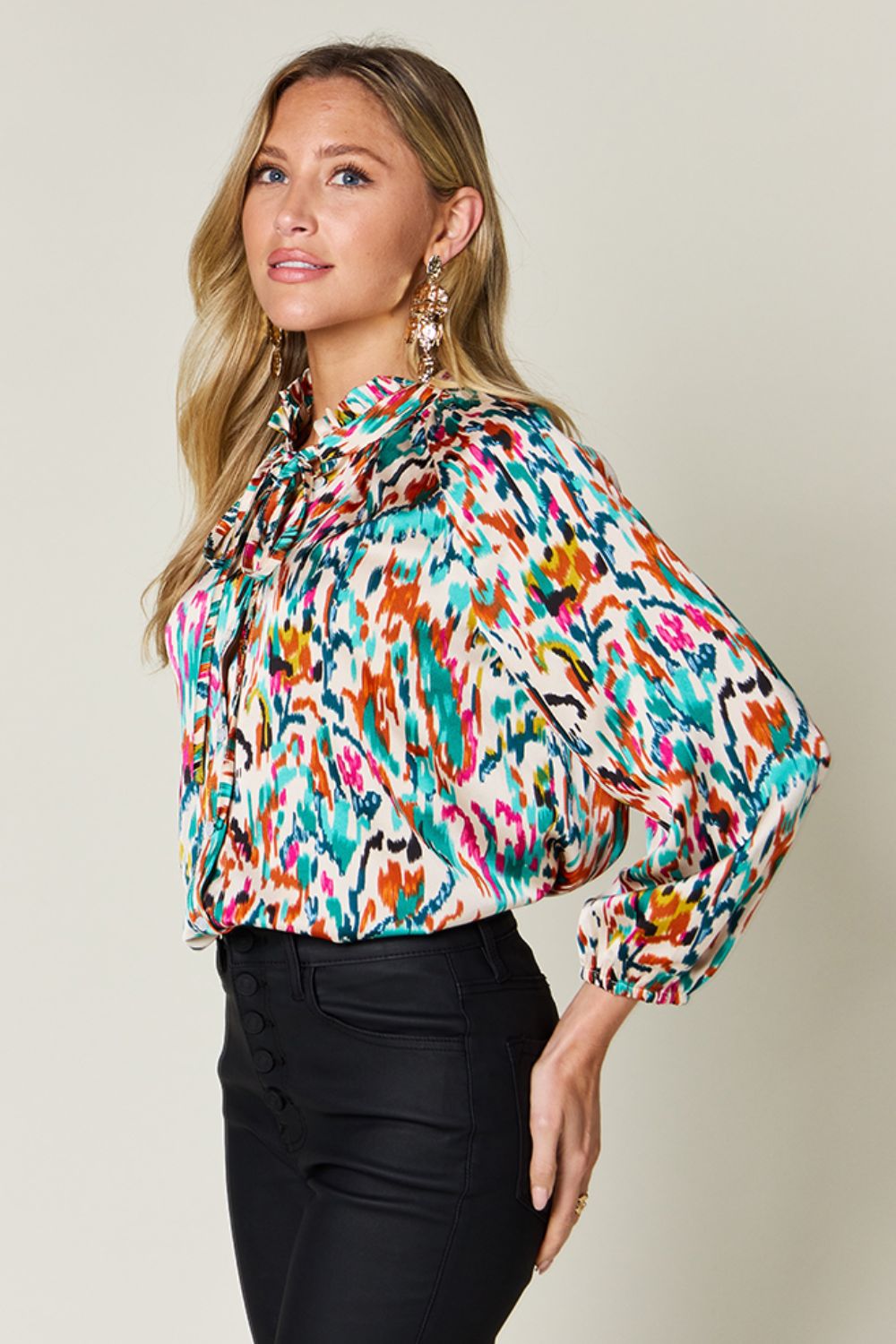 Silk tie-neck blouse with abstract ikat print and ruffled collar.