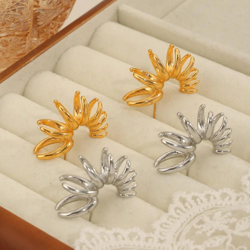 Sculptural petal drop earrings in gold and silver with unique layered design.