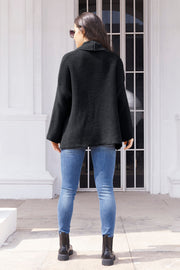 Black waffle knit cardigan with a shawl collar and relaxed fit, worn with jeans.