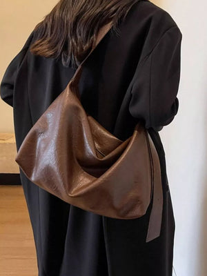 Brown faux leather slouchy shoulder bag with adjustable strap.