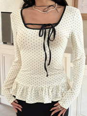 Ruffled polka dot long-sleeve t-shirt with black trim and tie-neck detail.