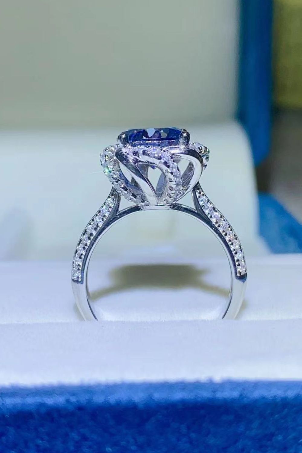 Blue moissanite halo ring with pave diamond band.