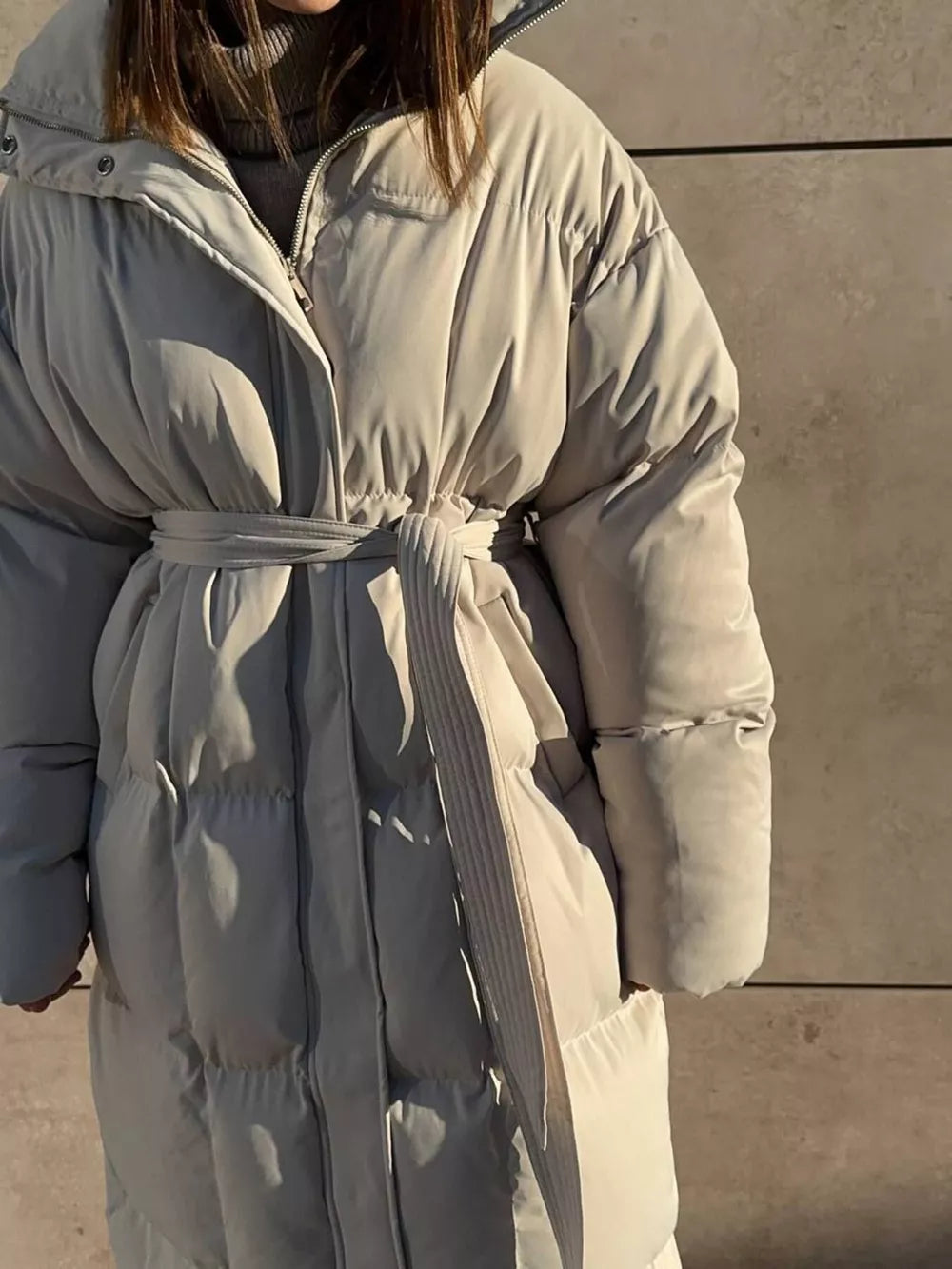 Puffer trench coat in ivory white with a tie belt and quilted detailing.