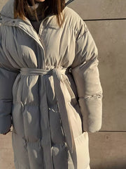 Puffer trench coat in ivory white with a tie belt and quilted detailing.