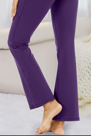 Violet flare-leg performance trousers with pockets shown on a model.