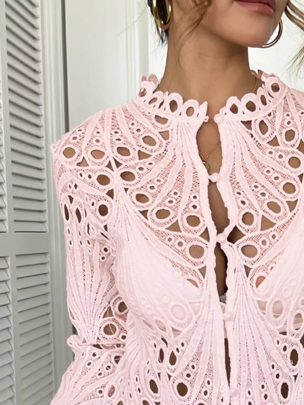 Pink lace button-up blouse with scalloped collar and intricate eyelet details.
