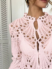 Pink lace button-up blouse with scalloped collar and intricate eyelet details.