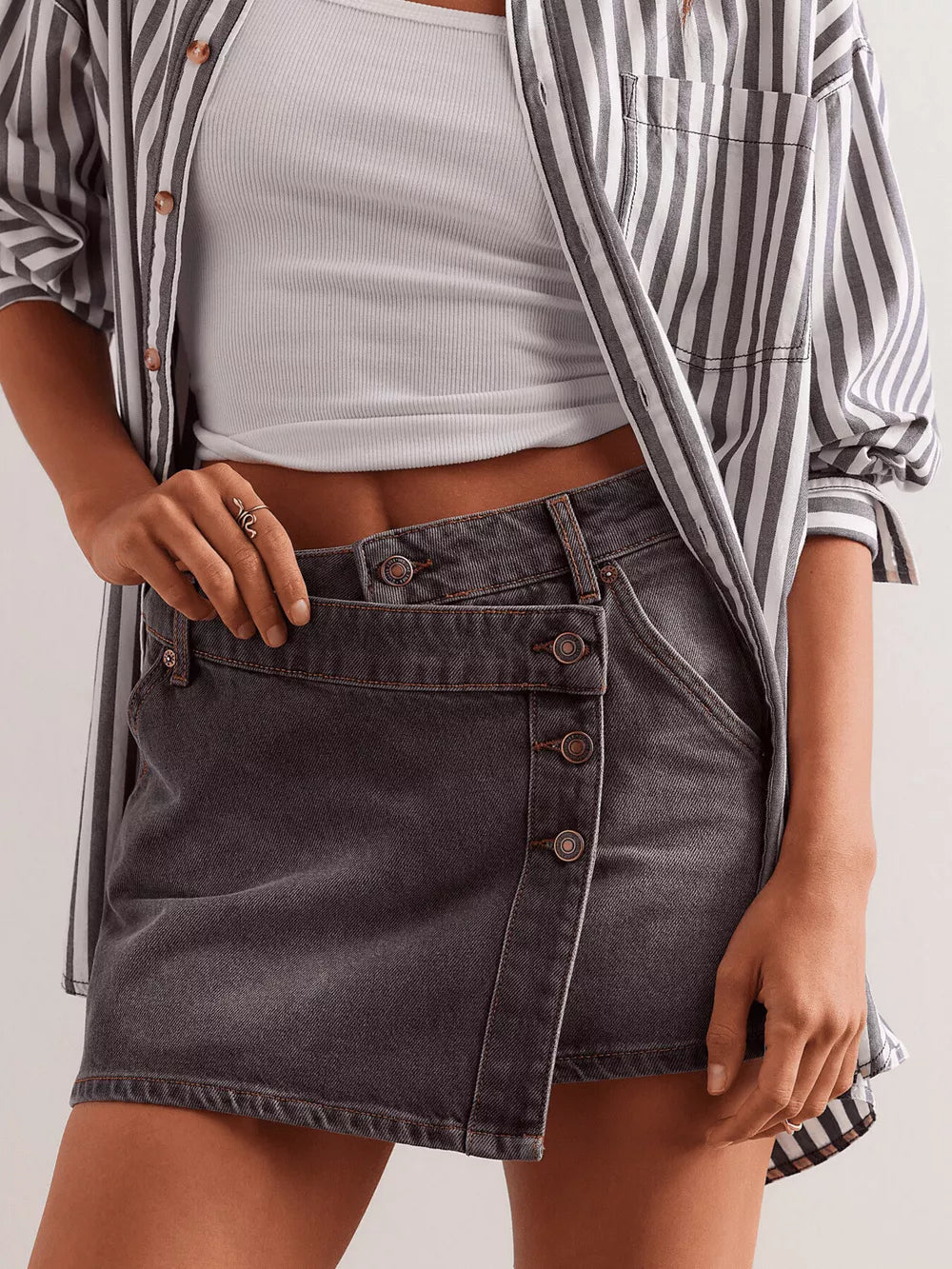Gray denim skort with asymmetrical button front and pocket detail.