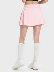 Pleated performance mini skirt in blush pink with a flared hem.