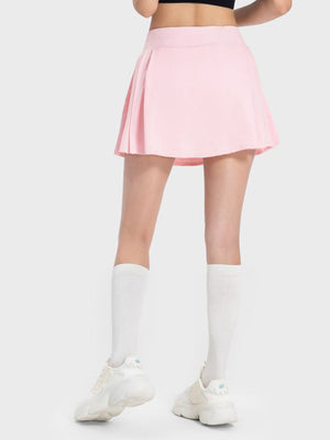 Pleated performance mini skirt in blush pink with a flared hem.