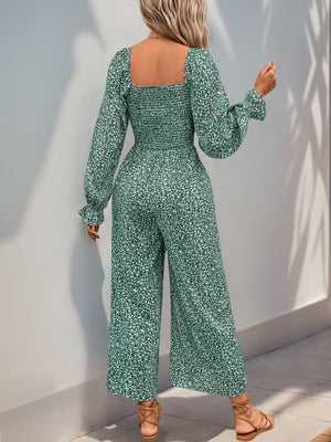 Turquoise floral jumpsuit with square neck, smocked waist, and wide legs.
