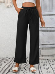 Black drawstring wide-leg pants with elastic waist and patch pockets.