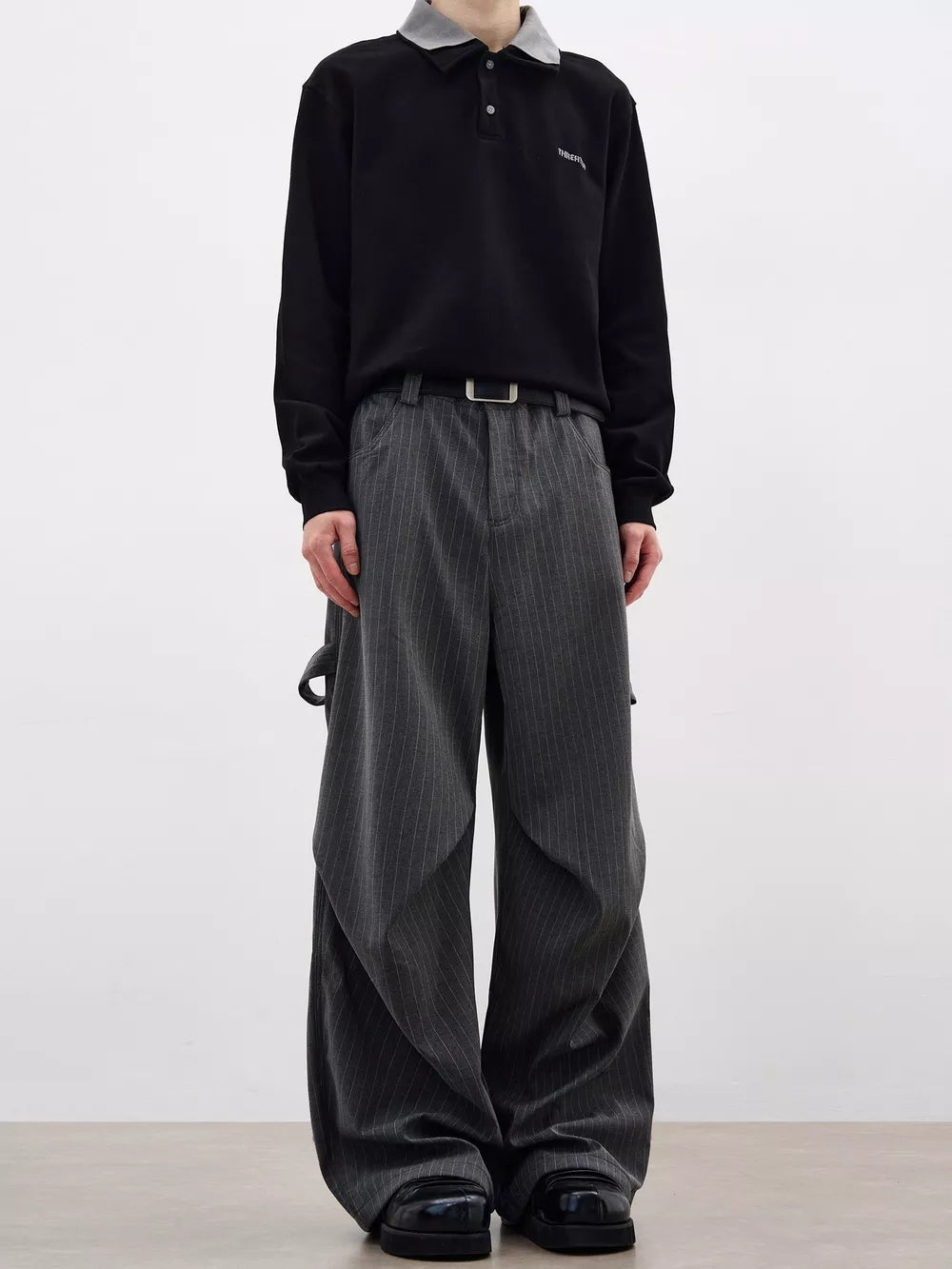 Men's grey pinstripe wide-leg sweatpants with pockets and belt loops.
