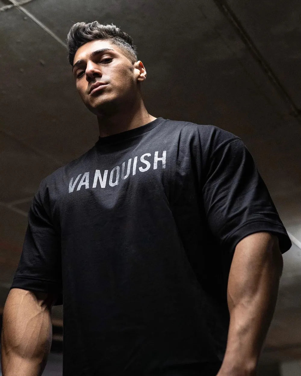 Black oversized t-shirt with white "VANQUISH" graphic print on chest