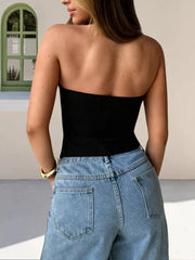 Black cropped halter tank top with a plunging V-neck, styled with high-waisted jeans.