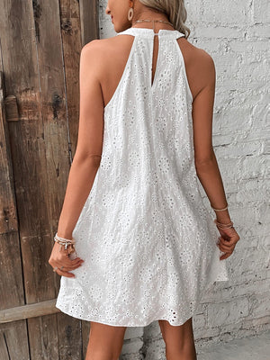 White eyelet halter trapeze dress with floral cutouts and a keyhole back detail.