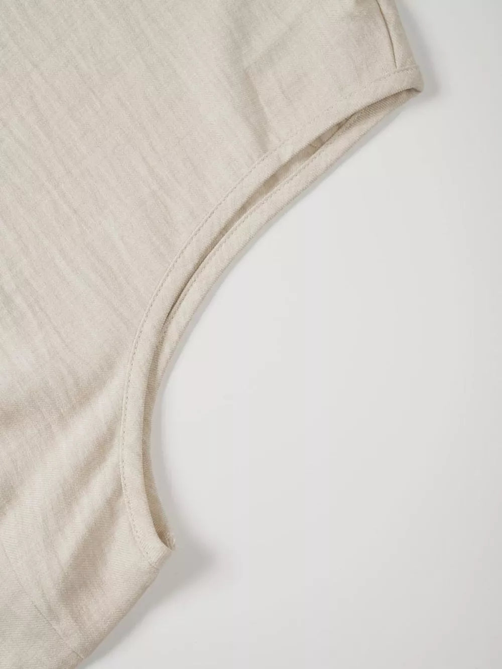 Textured beige sleeveless top with V-notch detail and clean seams