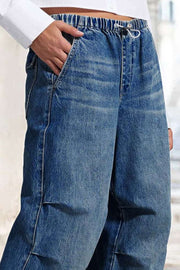 Elastic waist palazzo jeans in medium wash denim with a drawstring and wide leg.