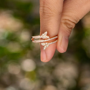 Gold bypass ring with two diamond-accented butterfly details.