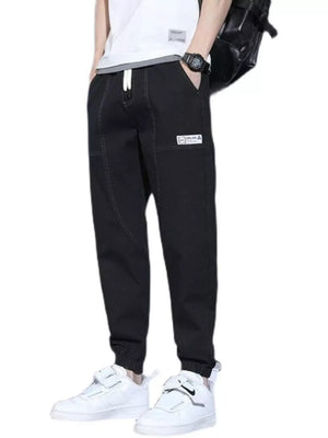 Black drawstring jogger jeans for men with a white drawstring and patch detail.