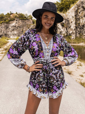 Floral print blouson sleeve romper in mauve with button front and ruffled hem.