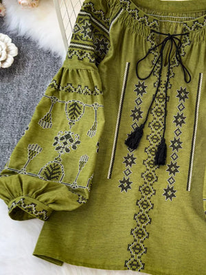 Green embroidered tie neck blouse with tassels and puff sleeves.