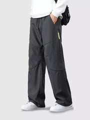 Men's gray loose fit cargo pants with drawstring and zip pocket detail.