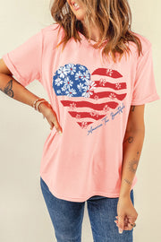 Pink graphic t-shirt with a floral American flag heart and text that says America The Beautiful.