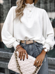 White textured puff sleeve blouse with smocked neck and cuffs.