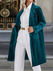 Deep teal velvet longline trench coat with lapel collar and buttoned front.