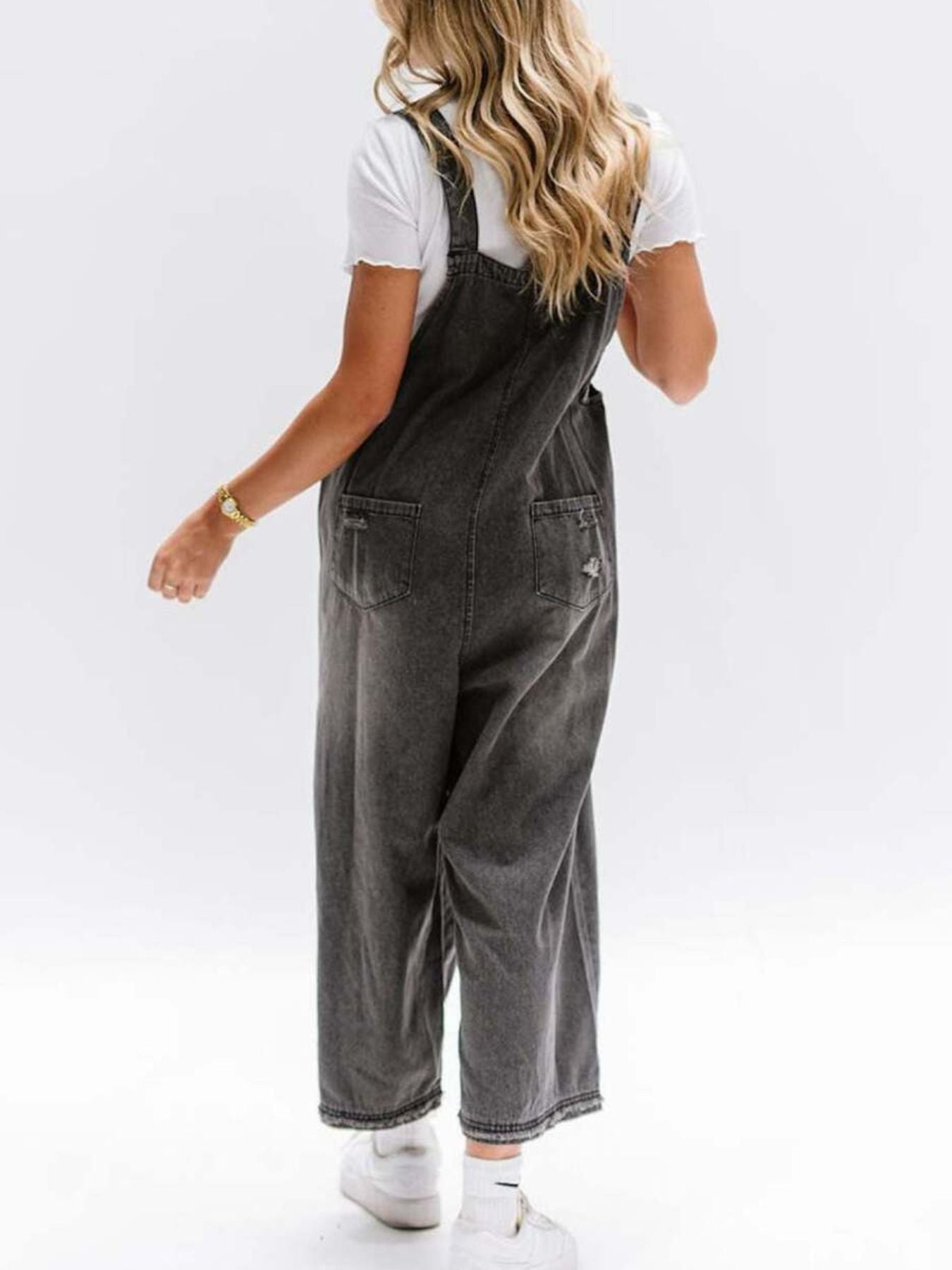 Ripped relaxed fit denim overalls in blue-black with distressed details and wide legs.