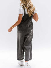 Ripped relaxed fit denim overalls in blue-black with distressed details and wide legs.