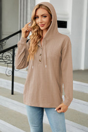Tan textured henley hooded knit top with button detail and drawstring hood.