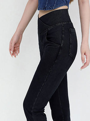 Crossover waist flare jeans in black denim with a high rise and bootcut leg.