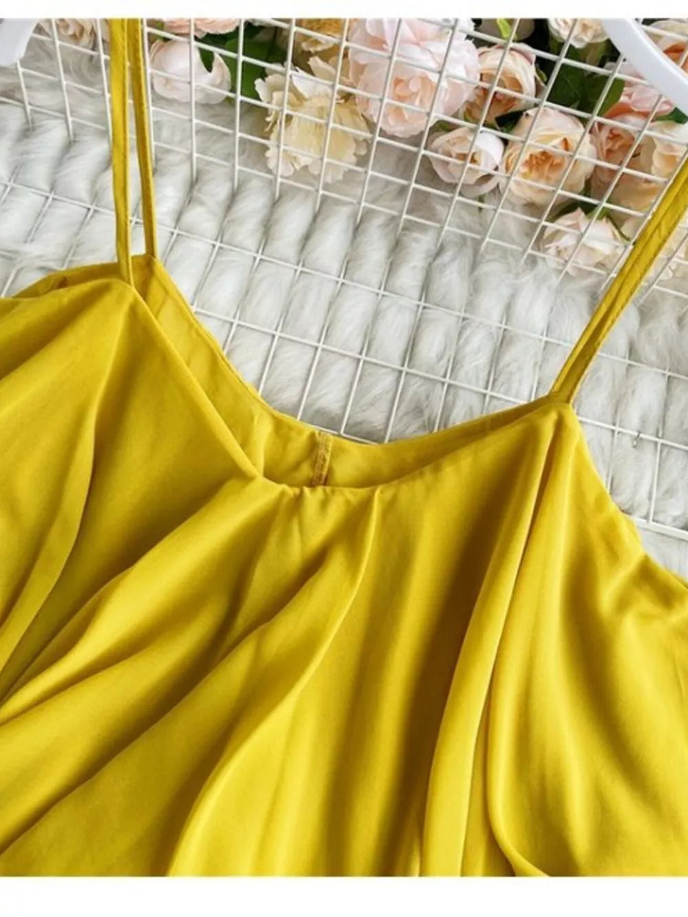 Yellow camisole with spaghetti straps and delicate ruffles.