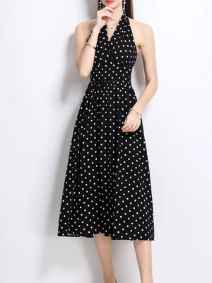 Black polka dot halter midi dress with V-neck and cinched waist.