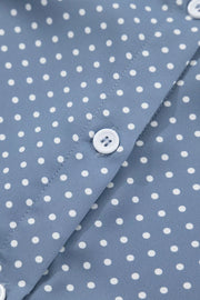 Polyester polka dot shirt with white buttons and cuffed short sleeves.