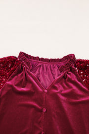 Red velvet blouse with sequin sleeves and ruffled neckline.