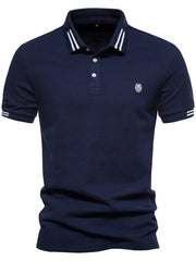 Navy polo shirt with striped collar and sleeve detail, featuring a textured knit and embroidered logo.