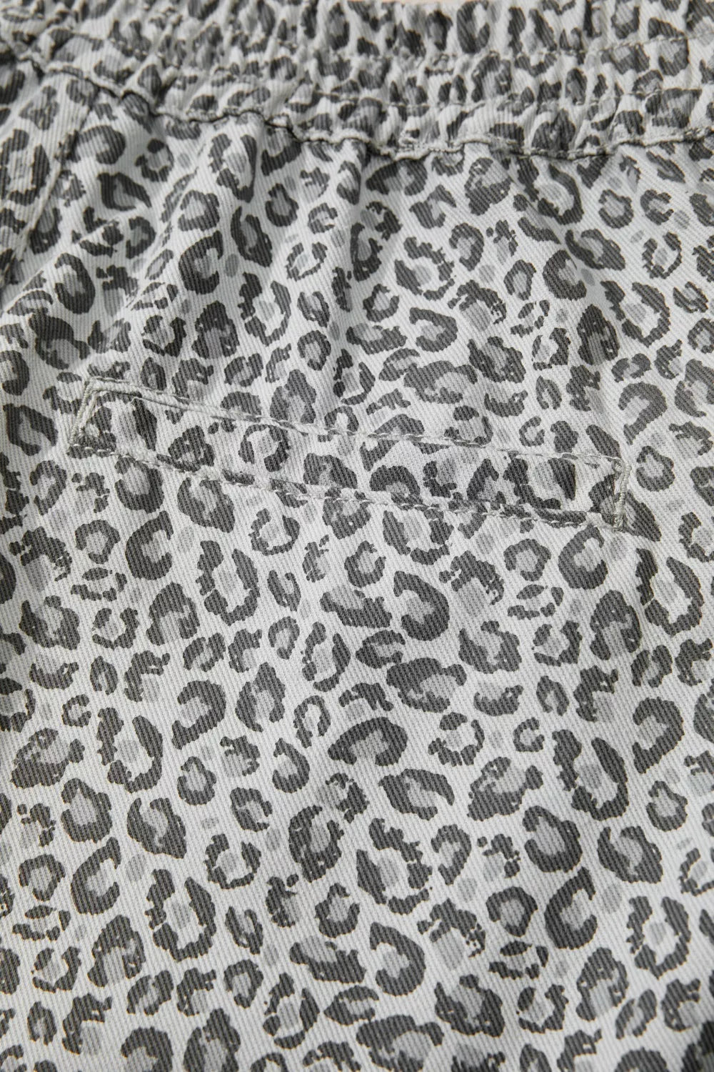 Denim shorts with a grey leopard print and elastic waistband.