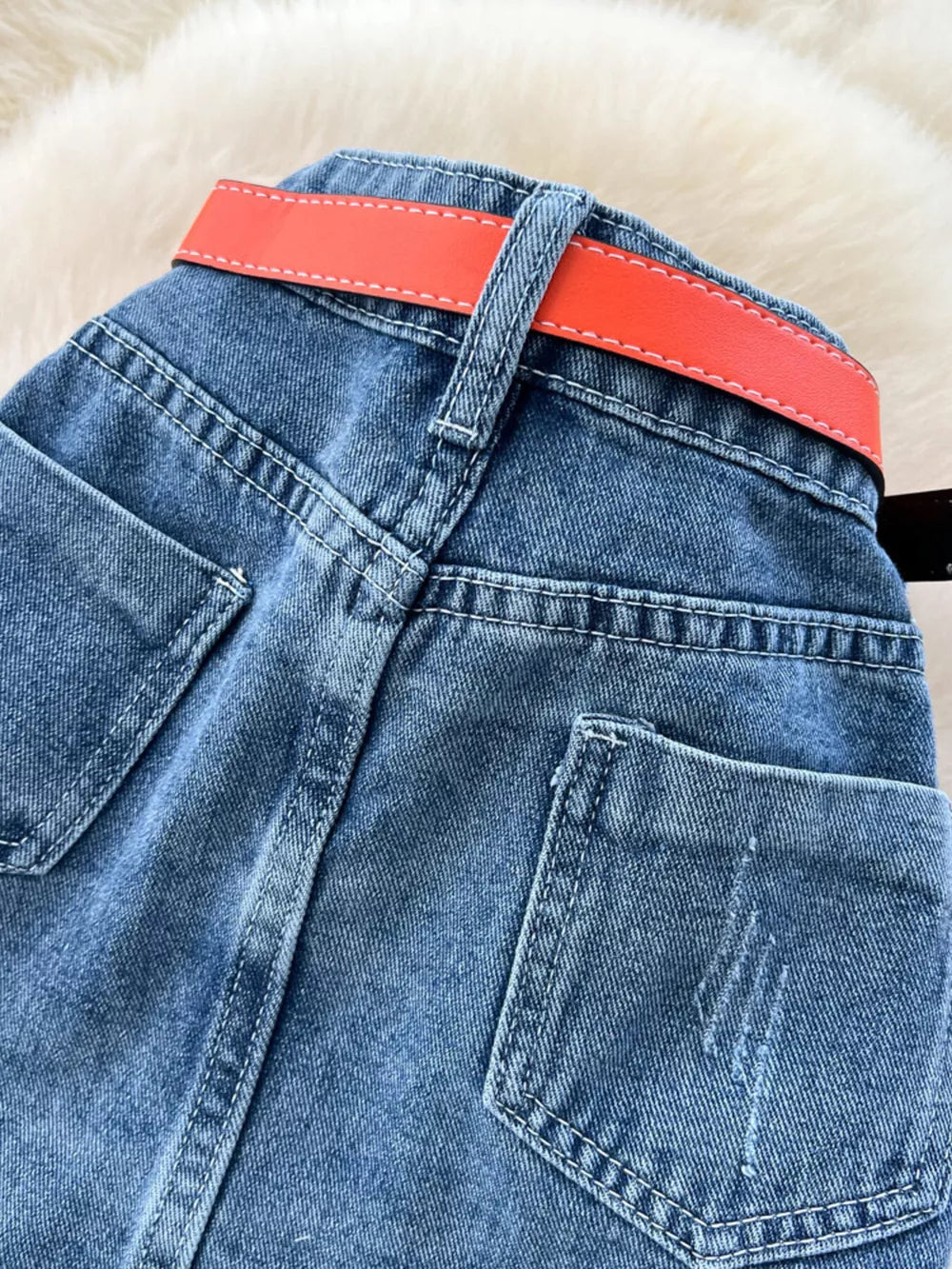 Patchwork denim midi skirt with red belt detail and contrast stitching.