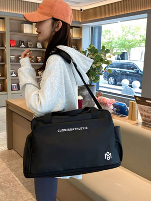 Black Oxford cloth travel duffle bag with adjustable strap and side pockets.