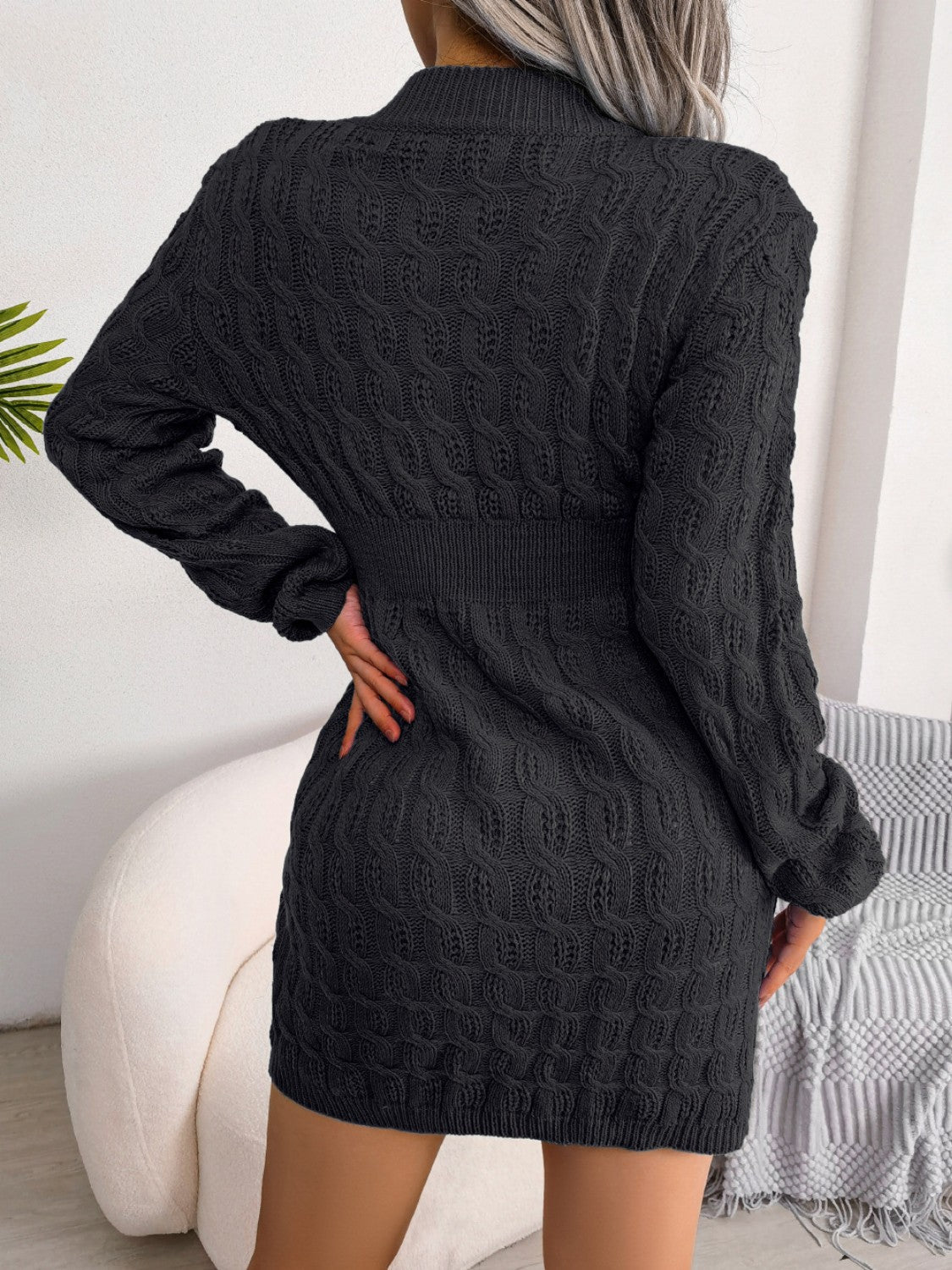 Black cable knit mini dress with long sleeves and sculpted fit