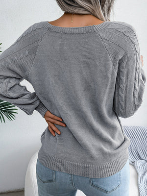 Charcoal cable-knit sweater with buttoned shoulder detail and crew neck.