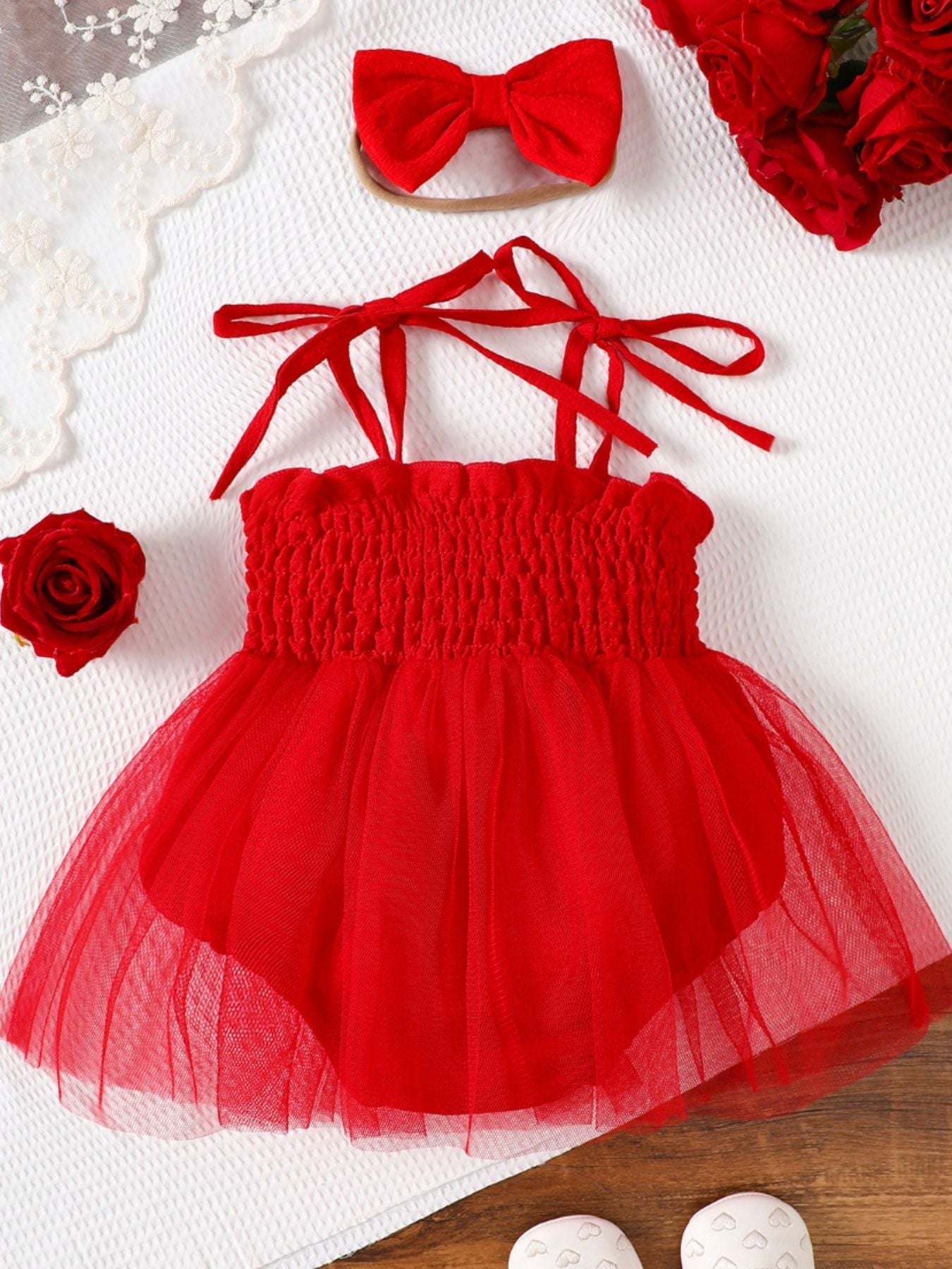 Red smocked bodysuit dress with tulle skirt and matching bow headband.