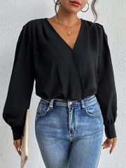 Black balloon sleeve surplice bodysuit with V-neck and cinched cuffs, styled with jeans.